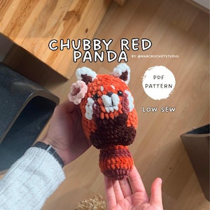 Pode incluir: Um bicho de pelúcia de panda vermelho de crochê, com detalhes em laranja, marrom e branco. O texto "CHUBBY RED PANDA" é exibido acima, com "PDF PATTERN" e "LOW SEW" em um círculo à direita. Feito à mão.