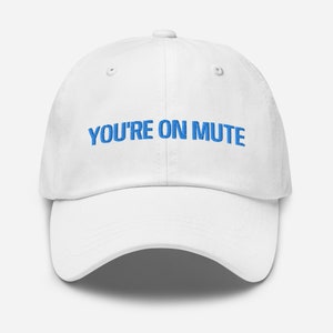 May include: White baseball cap with blue embroidered text that reads "YOU'RE ON MUTE".