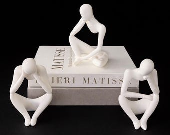 Set di 3 sculture astratte di figure sedute, stampate in 3D.