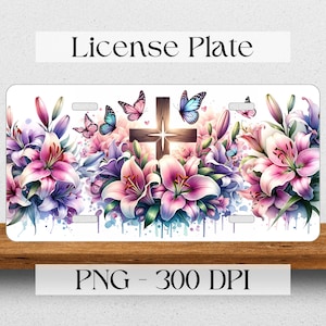 May include: A white license plate design featuring a wooden cross surrounded by pink and purple lilies and blue butterflies. The background is a watercolor wash of blue and pink.