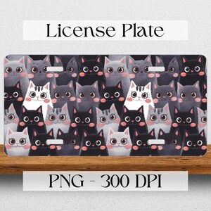 May include: A license plate featuring a pattern of black, gray, and white cats with pink noses and big eyes. The text "License Plate" is at the top of the image.