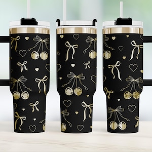 May include: Three black stainless steel tumblers with gold lids and straws. The tumblers are decorated with a pattern of gold cherries, bows, and hearts.