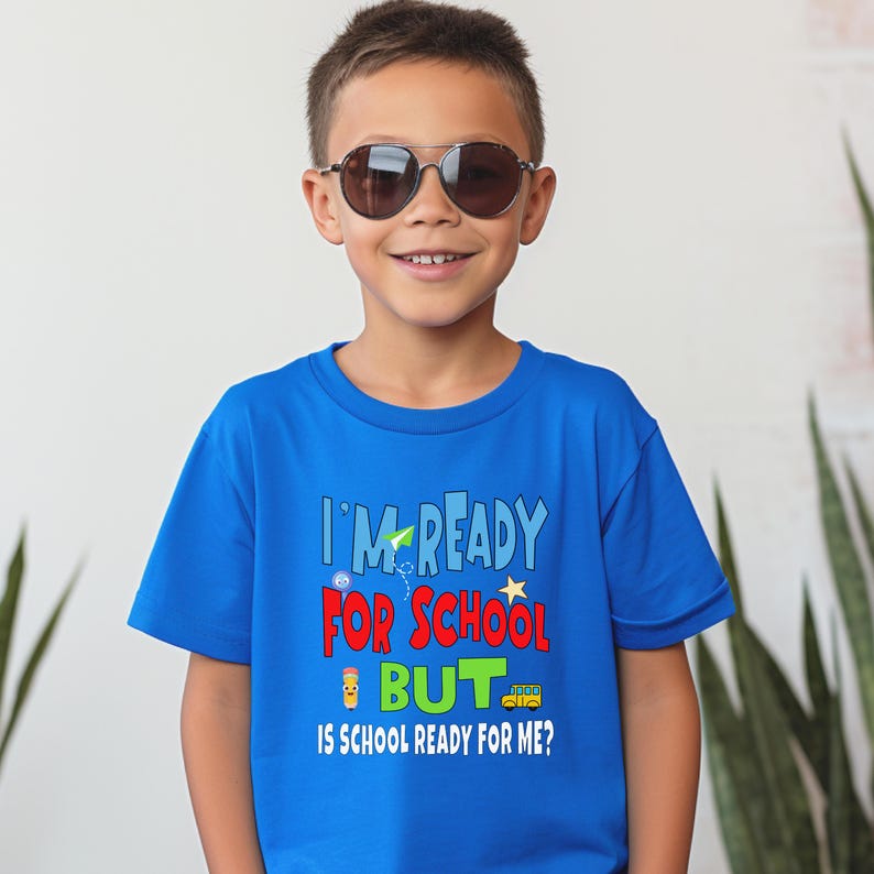 royal blue kids crewneck t-shirt that reads “I’m ready for school but is school ready for me?” in colorful letters with fun icons.