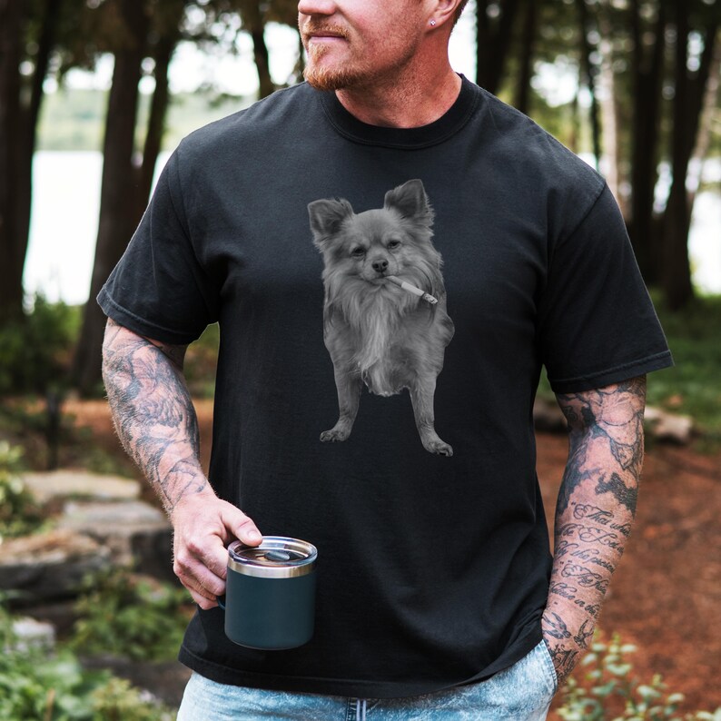 A black unisex Comfort Colors 1717 t-shirt featuring a grayscale image of a long hair Chihuahua standing with a cigarette in its mouth, giving a humorous, meme-style look perfect for dog lovers and fans of funny novelty shirts.