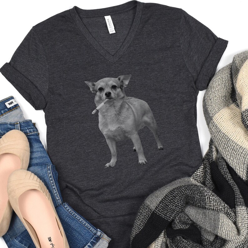 A dark heather grey vee-neck t-shirt featuring a grayscale image of a Chihuahua standing with a cigarette in its mouth, giving a humorous, meme-style look perfect for dog lovers and fans of funny novelty shirts.