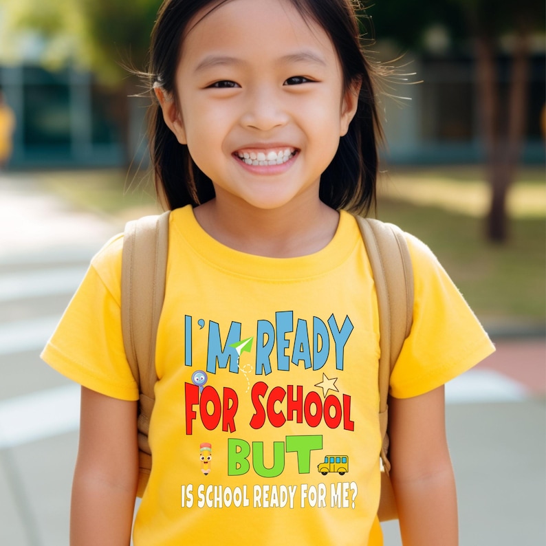 yellow kids crewneck t-shirt that reads “I’m ready for school but is school ready for me?” in colorful letters with fun icons.