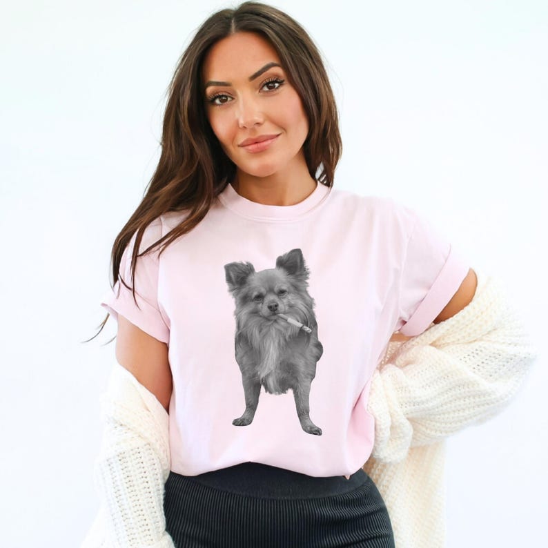 A blossom colored (light pink) unisex Comfort Colors 1717 t-shirt featuring a grayscale image of a long hair Chihuahua standing with a cigarette in its mouth, giving a humorous, meme-style look perfect for dog lovers and fans of funny novelty shirts.