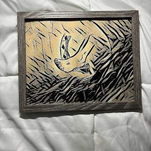 May include: A framed black and white abstract art print with a gold background. The print features a stylized image of a rhinoceros head.
