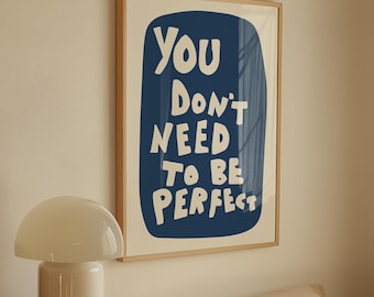 Könnte beinhalten: Ein gerahmter Kunstdruck mit dem Text "You Don't Need To Be Perfect" in Weiß auf dunkelblauem Hintergrund. Der Druck hängt über einem Bett mit cremefarbener Bettwäsche. Eine weiße Pilzlampe steht auf einer Holzkommode.