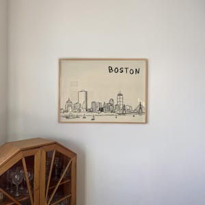 Minimalist hand-drawn sketch of Boston skyline in black ink on a beige background, organic modern wall art style.