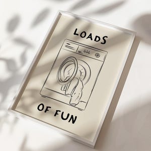 May include: A black and white illustration of a washing machine with the text "LOADS OF FUN" printed below it.