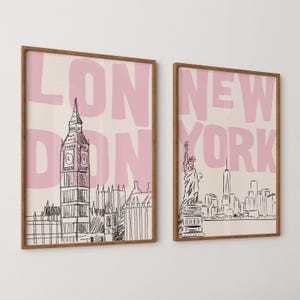 May include: Two framed wall art prints with light pink backgrounds. The left print features a black line drawing of Big Ben and the text LONDON. The right print features a black line drawing of the Statue of Liberty and the text NEW YORK.