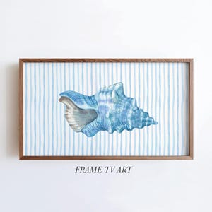 May include: A rectangular wooden frame containing a digital artwork of a blue seashell centered against a background of vertical light blue and white stripes. The text FRAME TV ART is printed in black below the framed image.