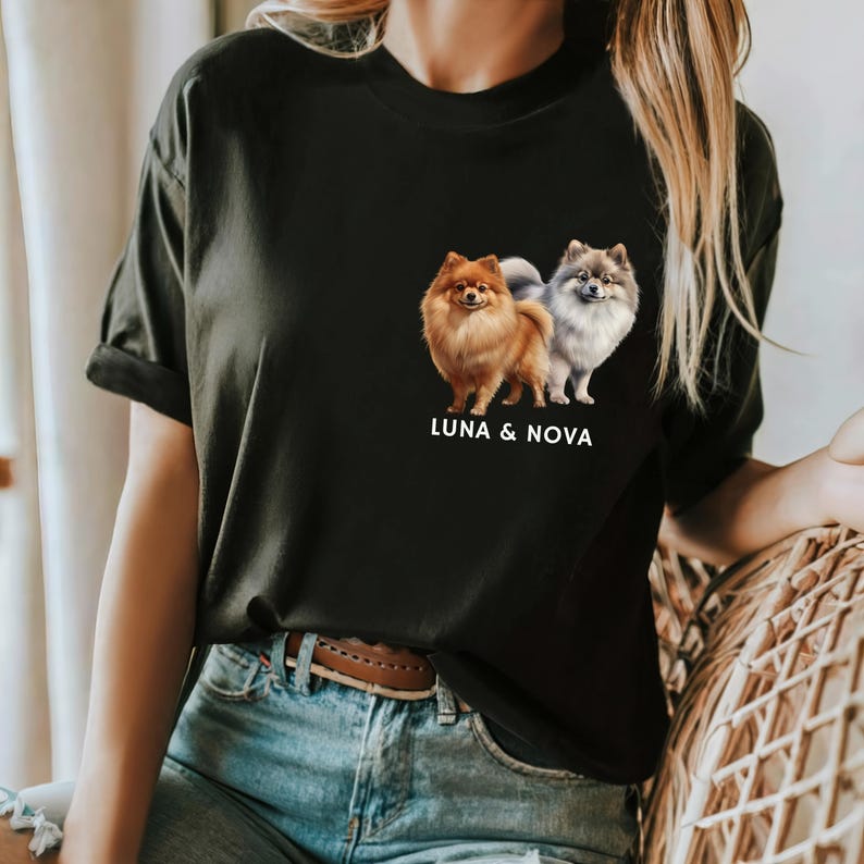 May include: Black t-shirt with a graphic of two Pomeranian dogs, one brown and one gray, with the text "LUNA & NOVA" underneath.