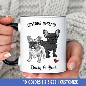 May include: White ceramic mug with a black rim and handle. The mug features a custom message that says "Custome Message" and a graphic of two French Bulldogs. The text below the graphic says "Daisy & Bear".