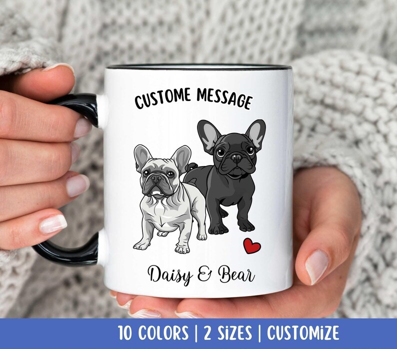 May include: White ceramic mug with a black rim and handle. The mug features a custom message that says "Custome Message" and a graphic of two French Bulldogs. The text below the graphic says "Daisy & Bear".
