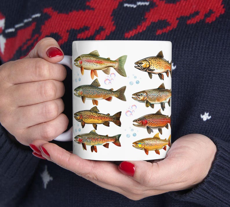 May include: White ceramic coffee mug featuring colorful illustrations of various fish species. The fish are depicted in shades of orange, yellow, brown, and green, with bubbles scattered around them. A unique gift for fishing enthusiasts.