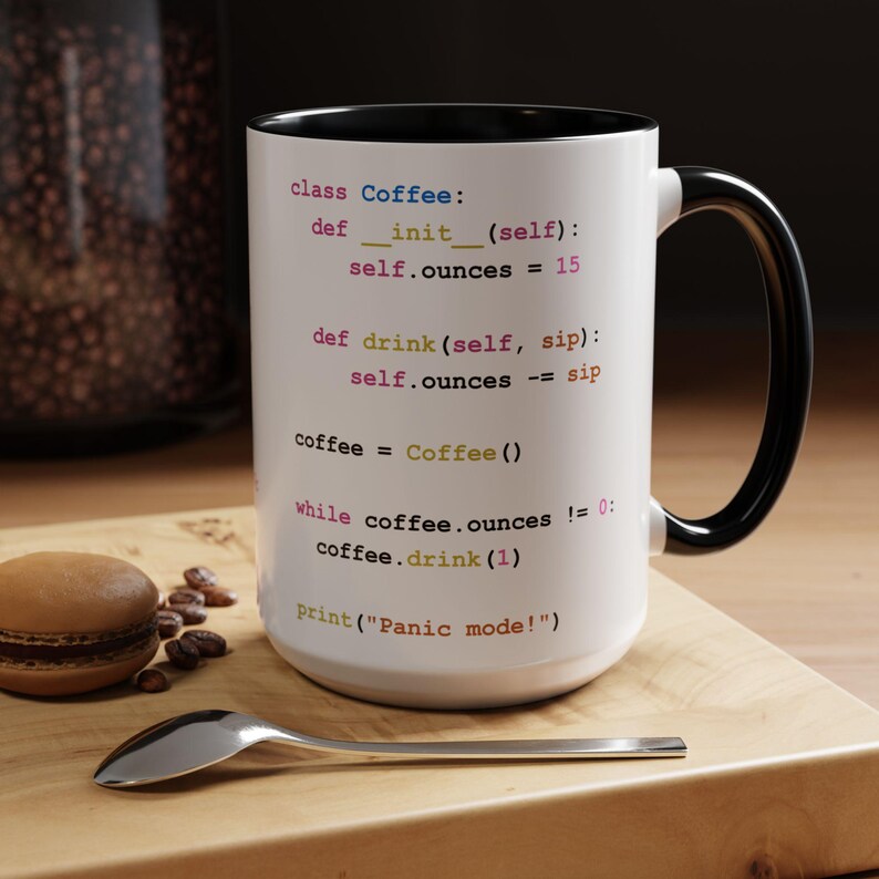 May include: White coffee mug with a black handle. The mug has a code snippet printed on it that reads: "class Coffee: def __init__(self): self.ounces = 15 def drink (self, sip): self.ounces -= sip coffee = Coffee () while coffee.ounces != 0: coffee.drink (1) print("Panic mode!")"
