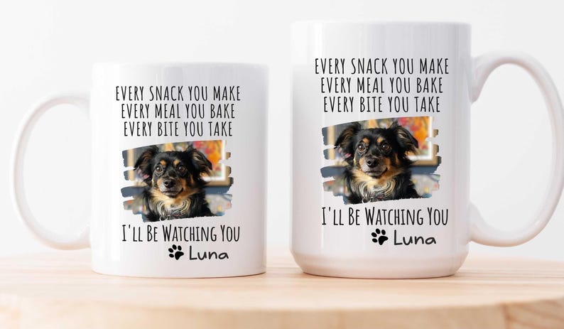 May include: Two white ceramic mugs with black text and a paw print. The text reads "Every snack you make, every meal you bake, every bite you take, I'll be watching you, Luna". Each mug features a photo of a brown and black dog.