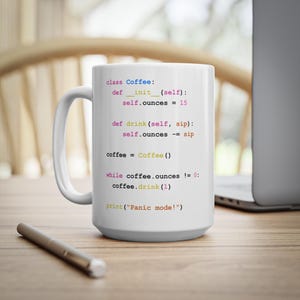 May include: White ceramic coffee mug with a humorous programming code printed on it. The code is written in Python and describes a coffee object with a drink method. The code includes the text "Panic mode!"