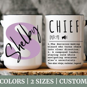 Puede incluir: Taza de cerámica blanca con asa y borde negros. La taza tiene una 'S' morada con el nombre "Shelby" escrito en cursiva negra. El otro lado de la taza tiene la palabra "CHIEF" en texto negro con una definición debajo. La definición dice: "[ti:f] 1. El mago de la toma de decisiones que convierte el caos en una dirección clara. 2. Un líder sereno, que permanece tranquilo mientras navega por la incertidumbre de todos. Ver también: ninja; rockstar; leyenda"