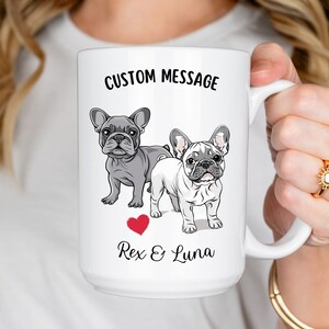 May include: White ceramic mug with a custom message, "CUSTOM MESSAGE", featuring a cartoon illustration of two French Bulldogs, one gray and one white, with a red heart and the text "Rex & Luna".