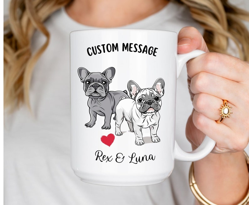 May include: White ceramic mug with a custom message, "CUSTOM MESSAGE", featuring a cartoon illustration of two French Bulldogs, one gray and one white, with a red heart and the text "Rex & Luna".