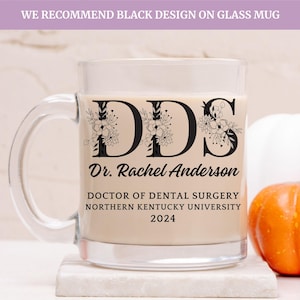 May include: A clear glass mug with a black floral design and the text "DDS Dr. Rachel Anderson DOCTOR OF DENTAL SURGERY NORTHERN KENTUCKY UNIVERSITY 2024".