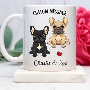 May include: White ceramic mug with a custom message that reads "CUSTOM MESSAGE" and features two cartoon French Bulldogs. The dogs are named Charlie and Rex. A red heart is between the dogs' names.