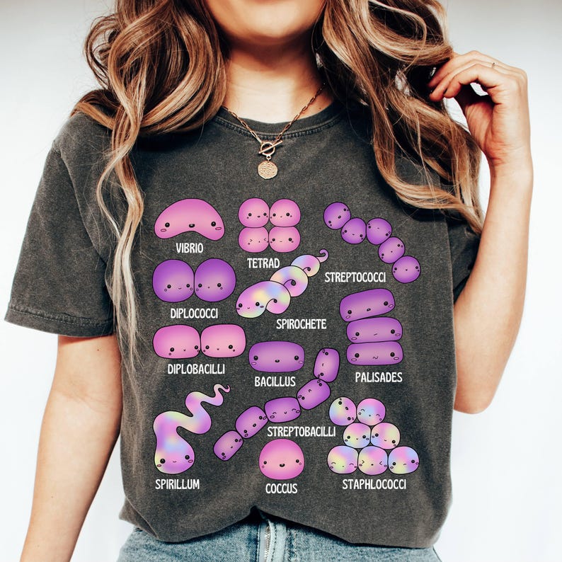 May include: Dark grey t-shirt with a colourful illustration of different bacteria, such as Vibrio and Spirochete. Each bacteria type is labelled with its name in a playful font, creating a unique science-themed graphic design.