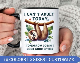 May include: White ceramic coffee mug with a black handle. The mug features a cartoon sloth hanging from a branch with the text "I can't adult today. Tomorrow doesn't look good either."