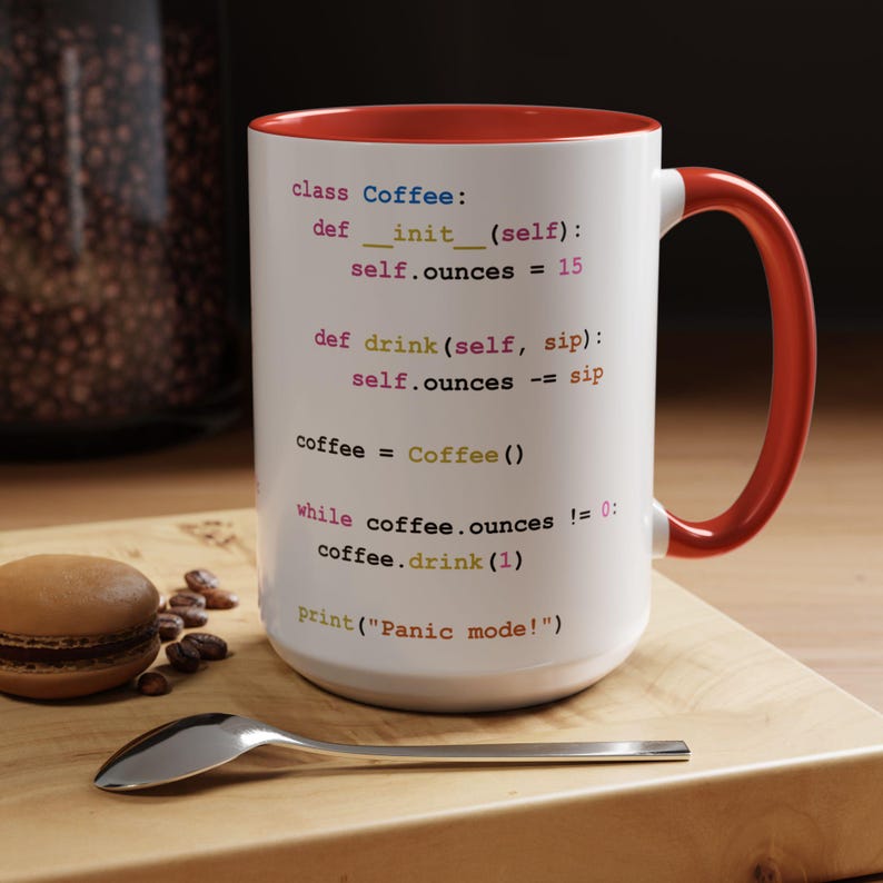 May include: White coffee mug with a red rim and handle. The mug features a code snippet in a light pink, blue, and yellow font. The code snippet reads: "class Coffee: def __init__(self): self.ounces = 15 def drink(self, sip): self.ounces -= sip coffee = Coffee() while coffee.ounces != 0: coffee.drink(1) print("Panic mode!")"