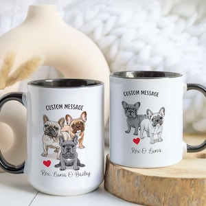 May include: Two white ceramic mugs with black handles and black rims. The mugs have a custom message printed on them. The left mug has a picture of three French Bulldogs with the text "Rex, Luna & Bailey". The right mug has a picture of two French Bulldogs with the text "Rex & Luna".