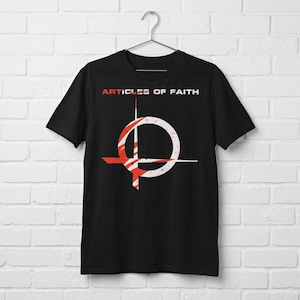 Peut inclure: Un t-shirt noir à manches courtes avec le texte ARTICLES OF FAITH en lettres blanches et rouges. Sous le texte se trouve un grand motif graphique circulaire en blanc et rouge avec un effet de peinture éclaboussée, centré sur la poitrine.