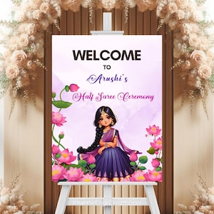 May include: A welcome sign for Arushi's Half Saree Ceremony. The sign features a cartoon illustration of a girl in a purple and gold saree, surrounded by pink lotus flowers. The words "WELCOME" and "Arushi's Half Saree Ceremony" are displayed in elegant fonts.