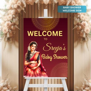 May include: Welcome to Sreeja's Baby Shower sign with a red background and gold accents. The sign features a woman in a red and gold sari holding her baby bump.