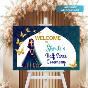 Könnte beinhalten: Willkommensschild für eine Halb-Saree-Zeremonie. Das Schild zeigt ein blaues und goldenes Design mit Schmetterlingen und einer Cartoon-Illustration eines Mädchens in einem blauen und grünen Sari. Der Text auf dem Schild lautet "Willkommen zur Halb-Saree-Zeremonie von Shruti".
