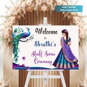 May include: Welcome sign for a half saree ceremony with a peacock illustration and a woman in a blue and purple saree. The sign reads "Welcome to Shruthi's Half Saree Ceremony".