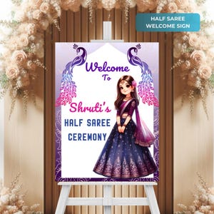May include: Welcome sign for a half saree ceremony with a purple and pink peacock design. The sign features a cartoon girl in a blue and purple saree with the text "Welcome to Shruti's Half Saree Ceremony".