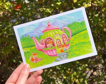 May include: A whimsical illustration of a teapot house with a pink and green exterior. Three foxes are depicted, one sitting in a window, one standing on a stone step, and one sitting on a blanket outside. The house is surrounded by green grass and trees, with mountains in the background.