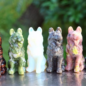 Peut inclure: Six figurines de loup sculptées, chacune d'une couleur différente. Les couleurs comprennent le marron, le vert, le blanc, le gris, le rose et le noir. Les loups sont tous en position assise, avec des détails sculptés.