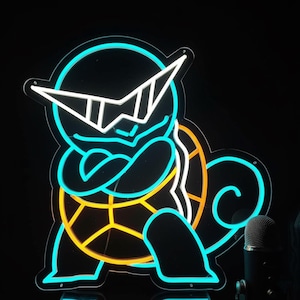 Può includere: Insegna al neon raffigurante un personaggio di tartaruga dei cartoni animati con occhiali da sole e le braccia incrociate. L'insegna ha uno sfondo nero con una combinazione di colori blu, bianco e giallo. Un microfono è visibile nell'angolo in basso a destra.
