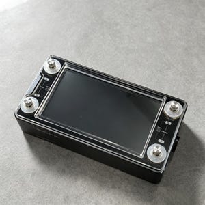 Könnte beinhalten: Ein schwarzer digitaler Gitarreneffektprozessor mit einem großen zentralen Touchscreen-Display, vier silbernen Metall-Fußschaltern mit klaren kreisförmigen Schutzvorrichtungen und weißen Aufdrucken wie Quad Cortex und A, B, C, D.