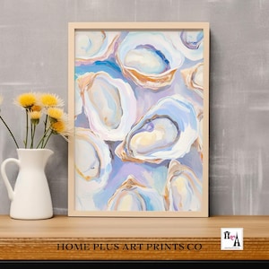 May include: An art print featuring an abstract painting of oysters in shades of blue, white, and gold. The artwork is framed in a light wood frame and rests on a wooden surface. A white pitcher with yellow flowers is to the left of the print.