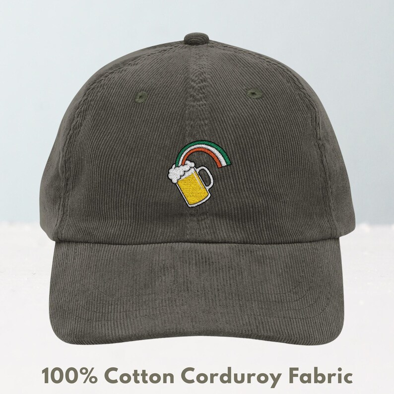 May include: Olive green corduroy baseball cap with an embroidered design of a beer mug and rainbow. The text "100% Cotton Corduroy Fabric" is printed at the bottom of the image.