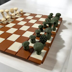 May include: A distinctive chess set with mushroom-shaped pieces in cream and green. The board has a brown and cream chequered pattern. The pieces are arranged on the board, ready for play.