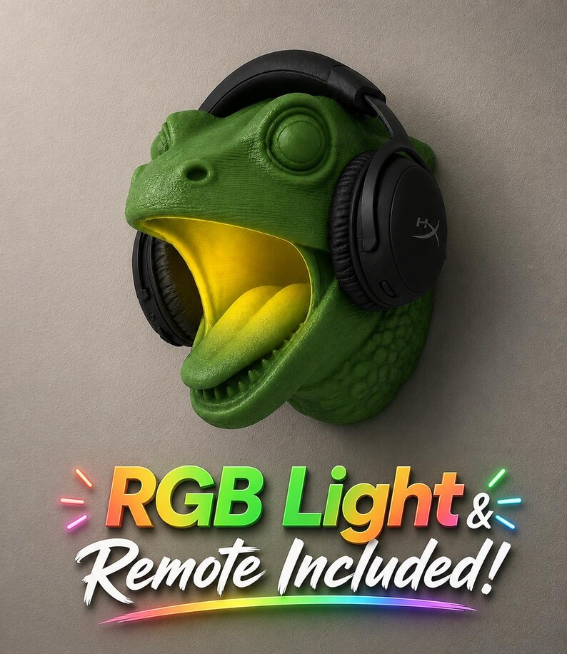 Op de afbeelding: Een groene dinosaurushoofd wandhouder met een gele binnenkant en een zwarte headset. De tekst "RGB Light & Remote Included!" wordt weergegeven in kleurrijke neonletters.