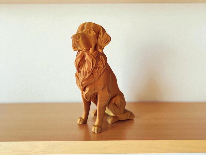Op de afbeelding: Een bruin hondenbeeld in zittende houding met gedetailleerde gravures. De sculptuur staat op een houten plank. De vacht en gezichtskenmerken van de hond zijn duidelijk zichtbaar. Een decoratief object.