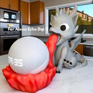 May include: A gray dragon-shaped speaker stand with a red tongue holding a white smart speaker. The speaker displays the time 09:35. The text "For Alexa Echo Dot 5" is visible.