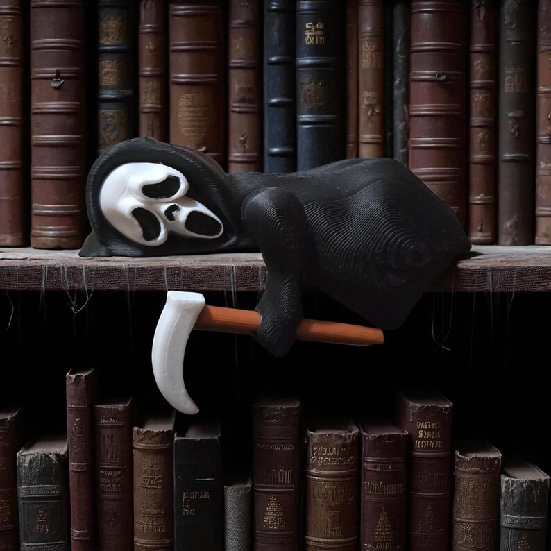 May include: A black Grim Reaper figurine with a white mask and a scythe. The figure is lying on a wooden shelf in front of a backdrop of antique books. The scythe has a white blade and a brown handle.
